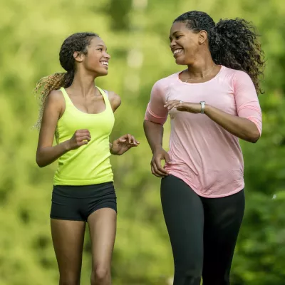 A mother running with her teenage daughter.