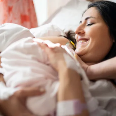 A new mom holds her infant after delivery. 