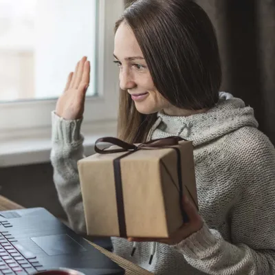 A woman doing a gift exchange on a video call.