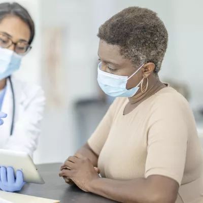 A woman at the doctor wearing a mask.