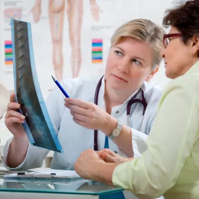 A woman looks at her back x-ray with her doctor