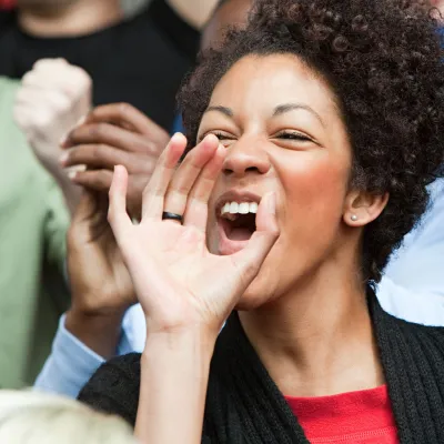 A woman cheers for her team at a sports game.