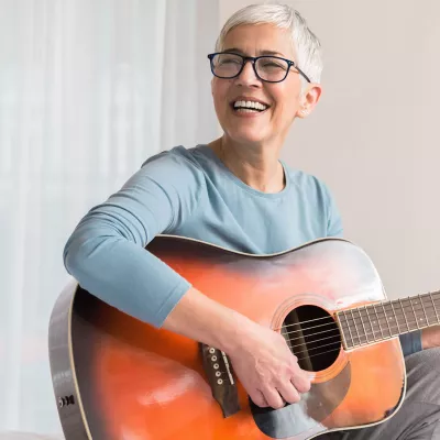 A woman strumming a guitar. 