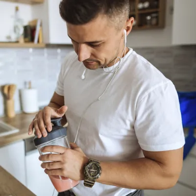A man making a shake and preparing for a workout.