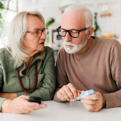 Older couple checking blood sugar