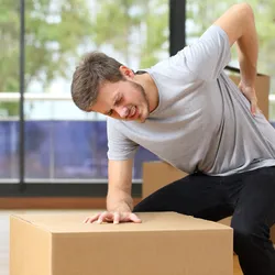 A man holds his back in pain.