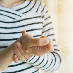 A woman holding her wrist