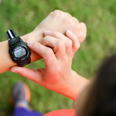 A man looking at his watch while exercising.