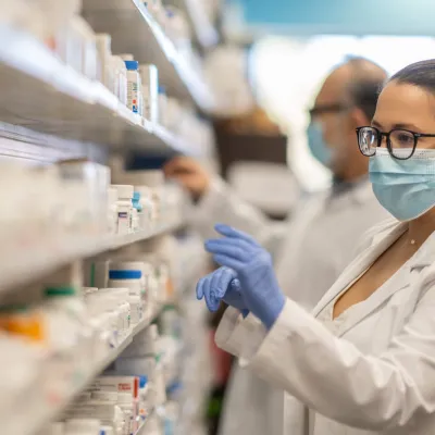 Female Pharmacist getting medication from shelf