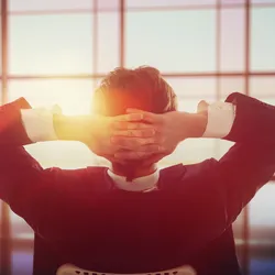 A man relaxes and looks out a window.