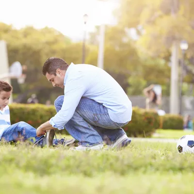 Man helping boy with his shoes