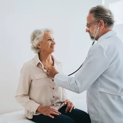 Older woman getting her heartbeat checked by a doctor.