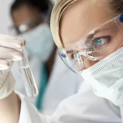 A woman looking at a test tube.