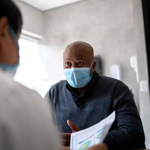 A Man Speaks to His Doctor in a Patient Room.