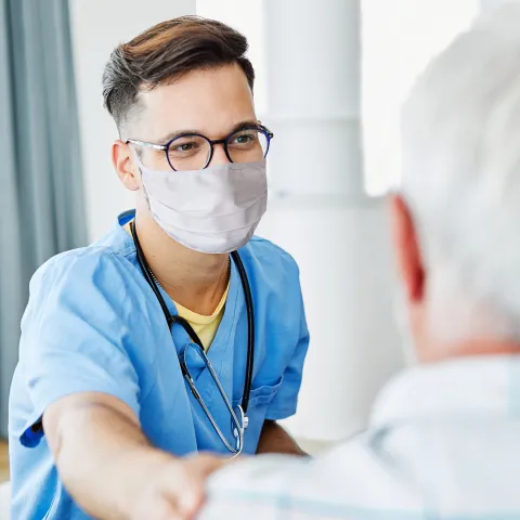 A Doctor Comforts an Elderly Patient in an Exam Room.