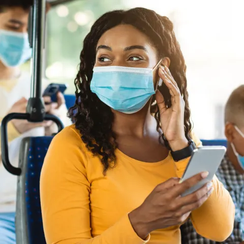 A Woman Rides the Bus with Her Little Brother While Using Her Smartphone.