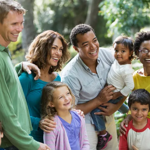 A Blended Family Walks Through a Park with a Guide.