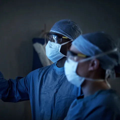A Pair of Surgeons Review an X-Ray as they Prepare for Surgery