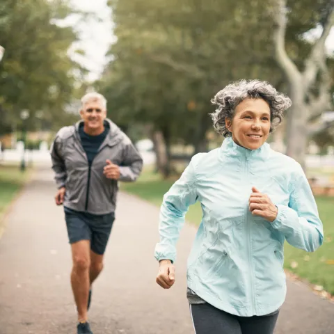 A Senior Couple Goes For a Jog Through the Park