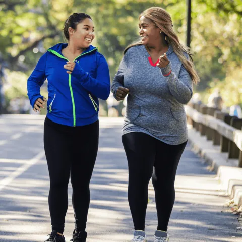 Two woman walking down the sidewalk