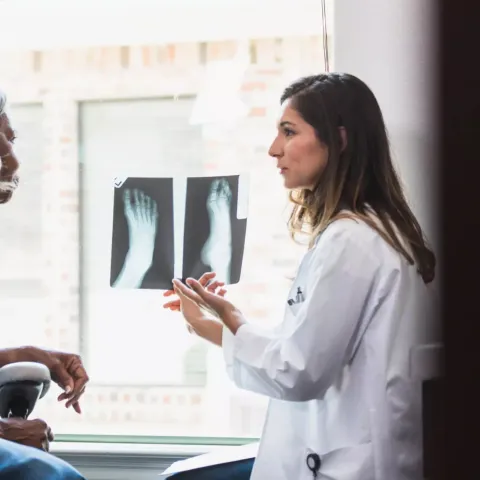 A Physician Goes Over a Patient's Foot X-rays with Her.