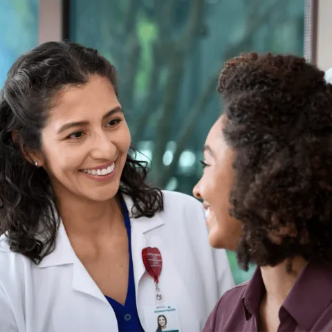 Female doctor smiling at female patient.