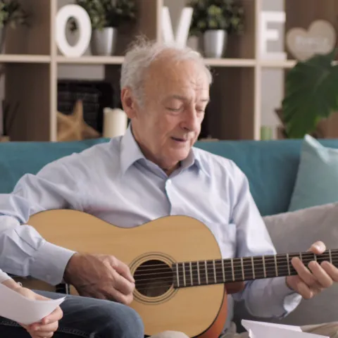 A grandfather playing guitar.