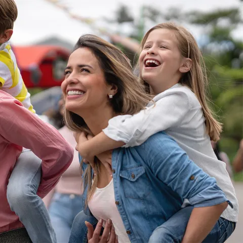 Two parents carrying on their backs their son and daughter.