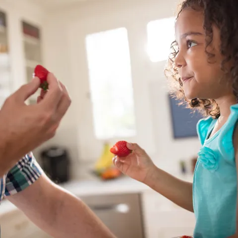Sharing a snack with her grandfather.
