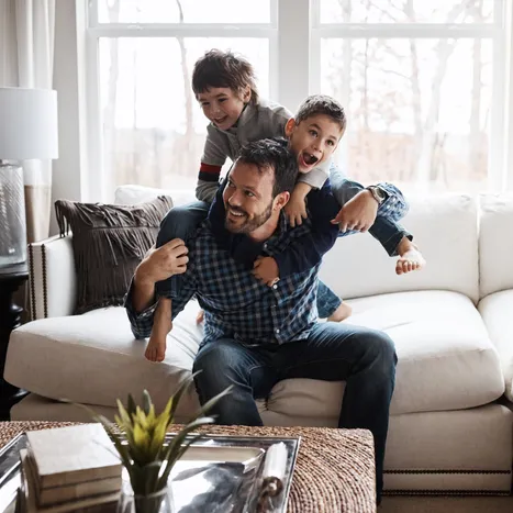 A father playing with his two children.