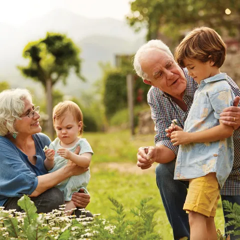 Grandparents with grandchildren in garden.
