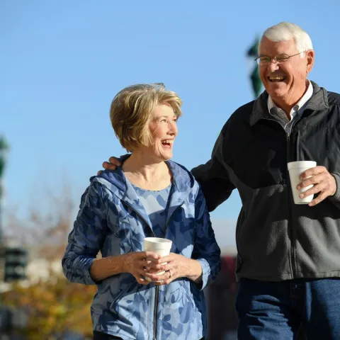 Elderly man and woman walking together in town