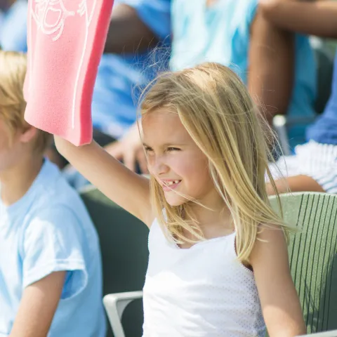 A family cheers on their favorite team at a sporting event.