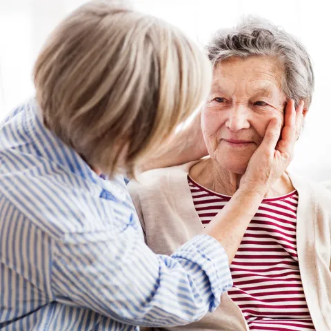 A daughter checks her mother for signs of a stroke.