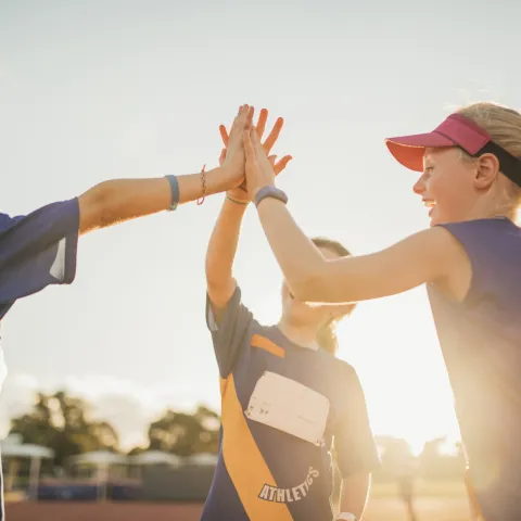 Young athletes high five after a good practice.