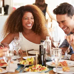 Several happy people eating at a table.