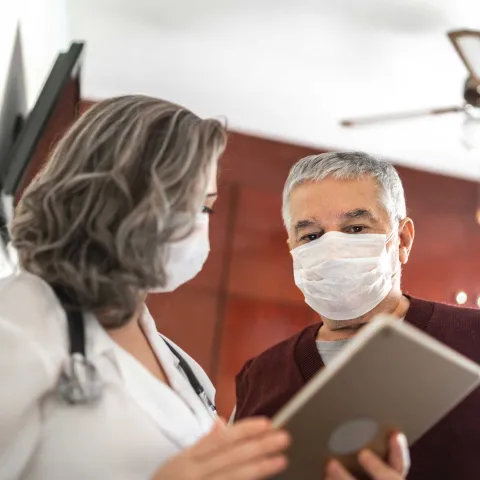Mature female doctor talking to a male patient