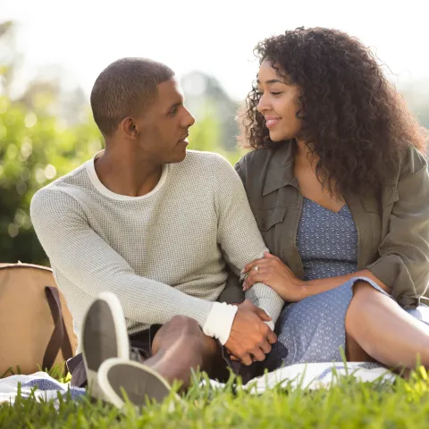 Couple holding hands during a picnic.
