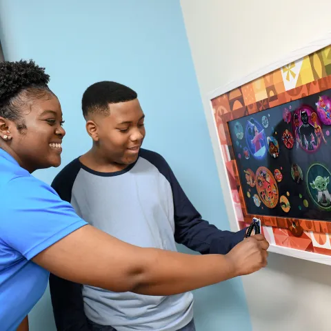 AdventHealth for Children employee showing a patient how to use Magic Art