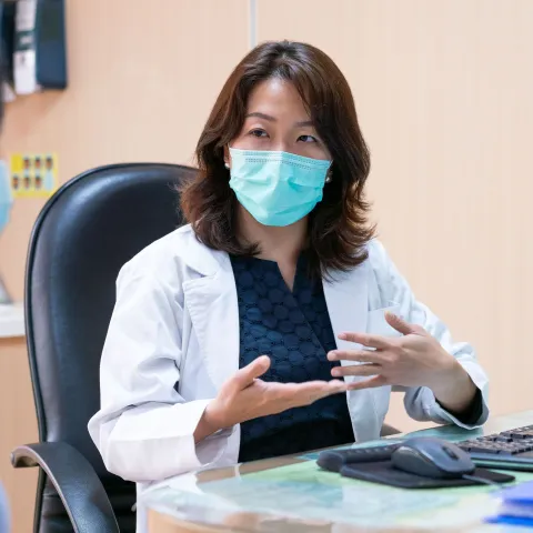 A doctor and patient during an office visit wearing masks.