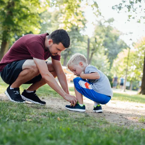 man helping boy with his shoes