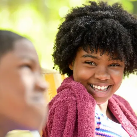 A girl smiles at her older brother
