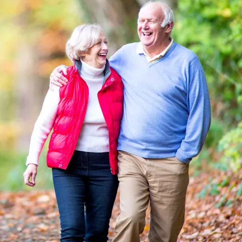 A happy older couple walking outdoors. 