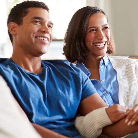 A happy couple on the couch. 