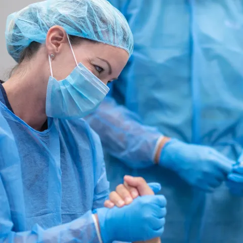 A doctor holding a patient's hand in the emergency room. 