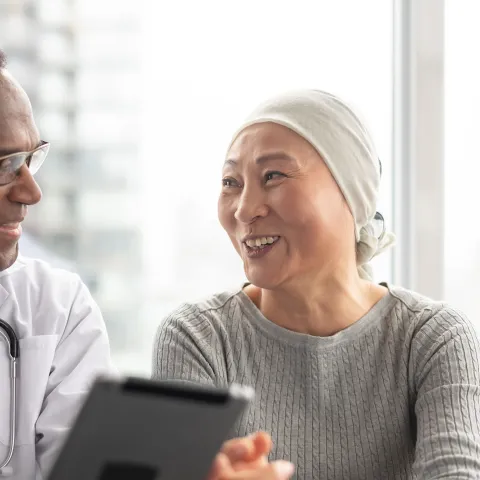 A doctor speaks with a patient undergoing cancer treatment. 