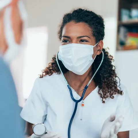 Doctors talking with each other while wearing masks.