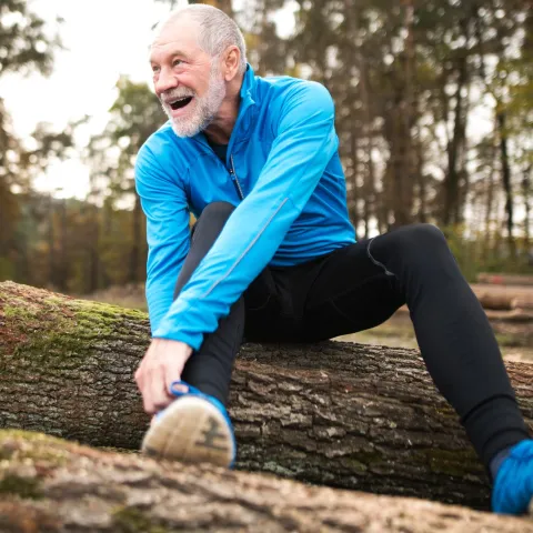 A man stretches outdoors.