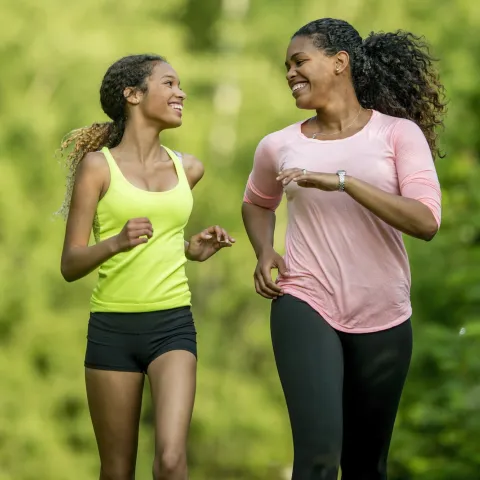 A mother running with her teenage daughter.