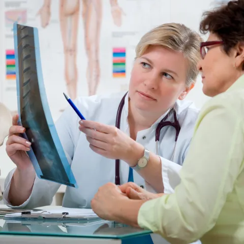 A woman looks at her back x-ray with her doctor